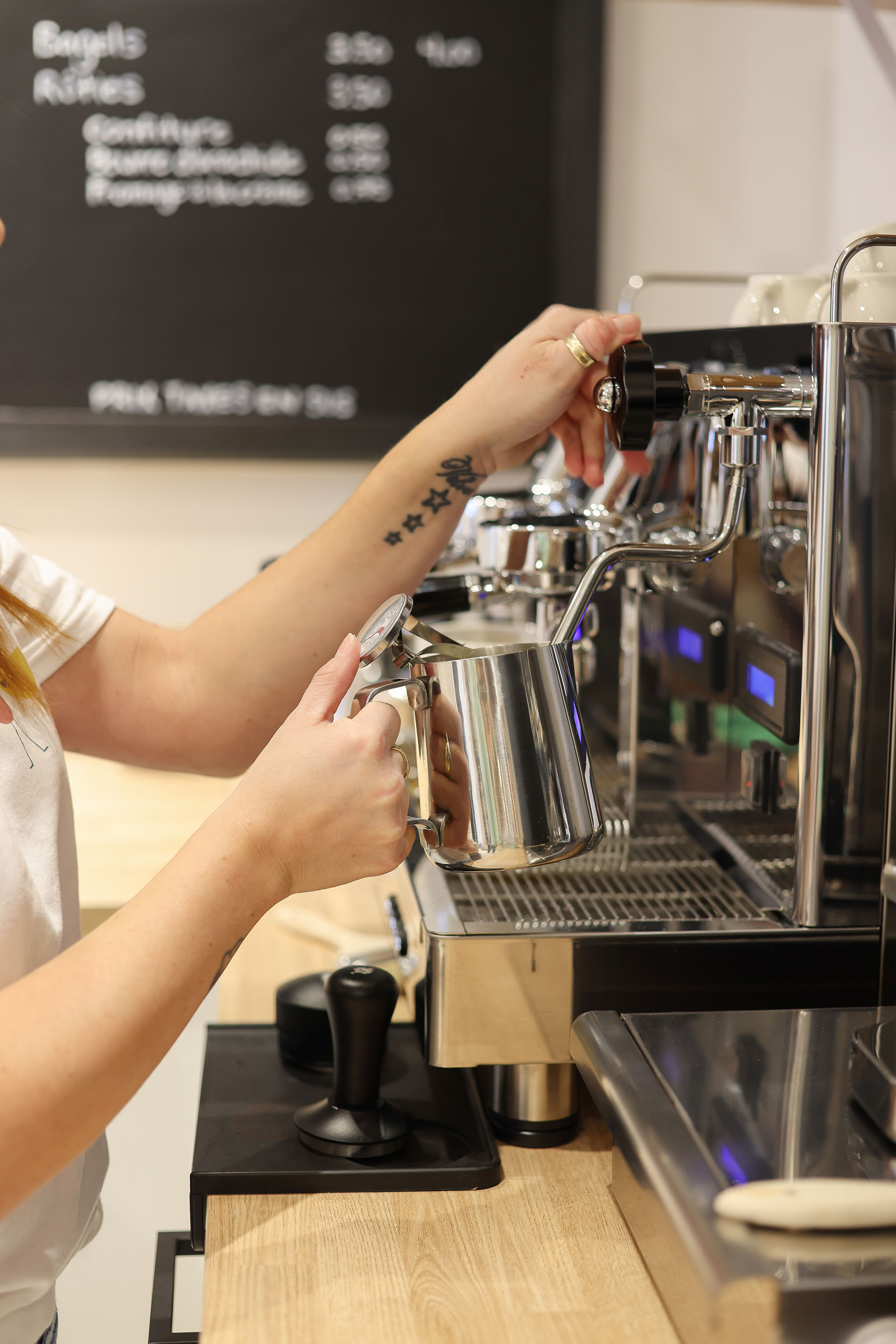 Barista qui verse du lait moussé dans un espresso